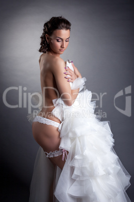 Curvy brunette bride posing in white lingerie
