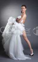 Smiling naked model covered by wedding dress