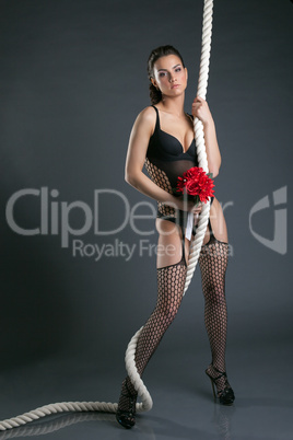 Attractive model posing with rope and bouquet