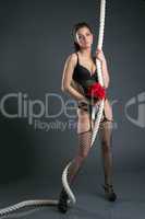 Attractive model posing with rope and bouquet
