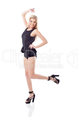 Smiling athletic blonde jumping in studio