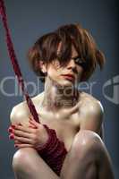 Portrait of passionate red-haired girl with rope