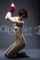 Young flexible nude woman posing tied with rope