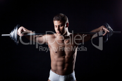 Portrait of attractive guy posing with barbell