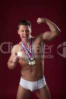 Image of smiling muscular guy posing with medals
