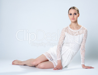 Graceful young girl posing in white lace dress