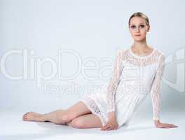 Graceful young girl posing in white lace dress