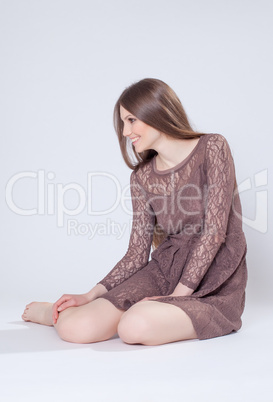 Smiling model posing in brown lace dress