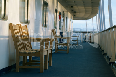 wooden chairs on the deck of cruise liner