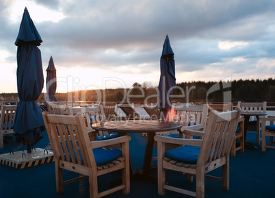 tables in outdoor bar on stern of cruise liner