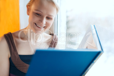 young smiling woman reading a book