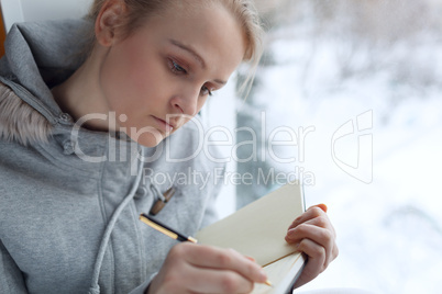 young girl writing in her journal.