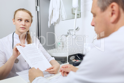 nurse shows to doctor results of analyses