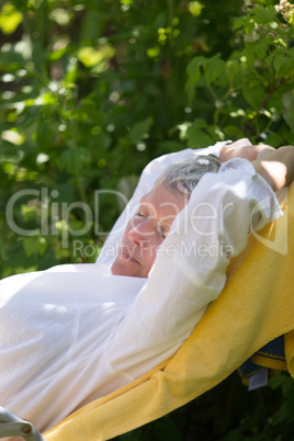 Senior woman sleeping on lounger