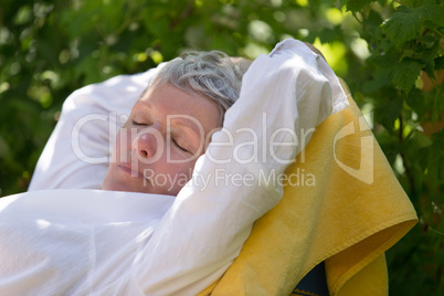 Senior woman sleeping on lounger