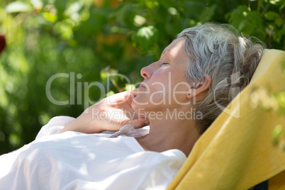 Aged woman sleeping on lounger