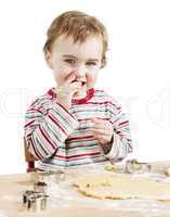happy young child nibbling dough in white background