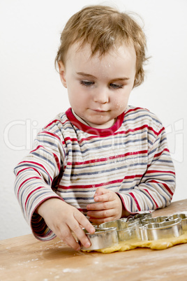 young child making cookies