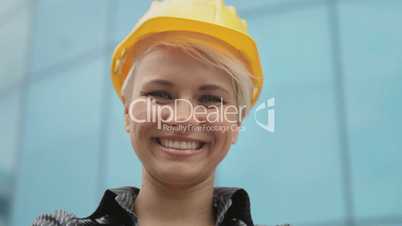 Portrait of female engineer with helmet smiling at camera