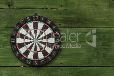 Dart board on a green wooden wall