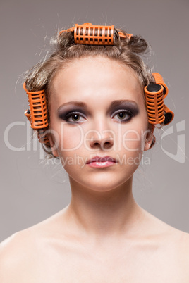 Stylish girl portrait with fashion makeup and hair curlers, isol