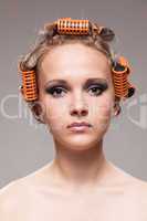 Stylish girl portrait with fashion makeup and hair curlers, isol