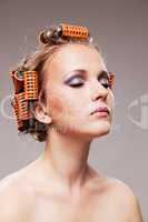 Stylish girl portrait with fashion makeup and hair curlers, isol