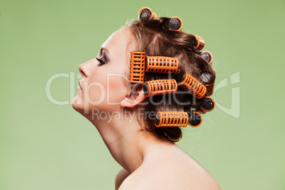 Stylish girl portrait with fashion makeup and hair curlers, isol