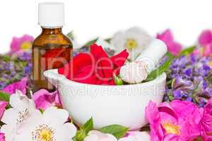 Essential oil and rose blossoms in mortar