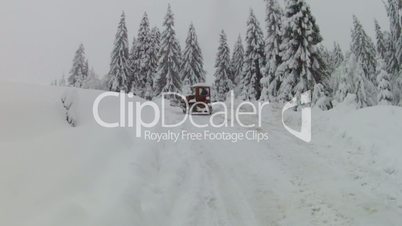 Bulldozer moving on snowy road, slow motion