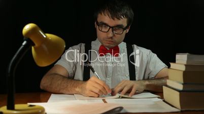 Funny nerd man writing at night