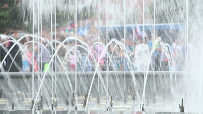 splashes of fountain water and crowd of people