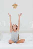 Cute girl throwing her teddy bear in the air