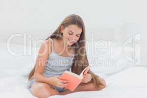 Happy young girl reading a book