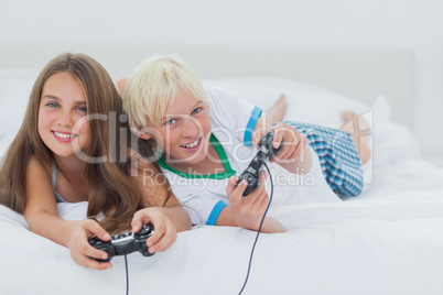 Cheerful siblings playing video games