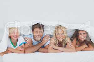 Smiling family lying on the bed