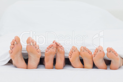 Family on the bed showing their feet