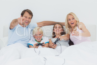 Children playing video games in bed