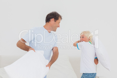 Father and son having a pillow fight