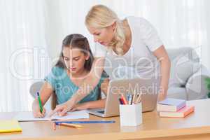 Mother helping her daughter to do her homework