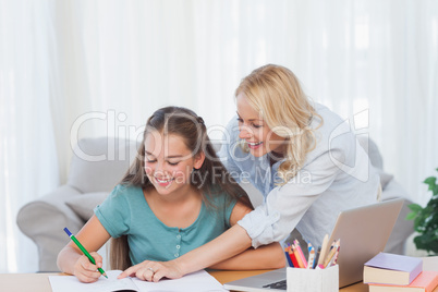 Mother pointing the book of her daughter