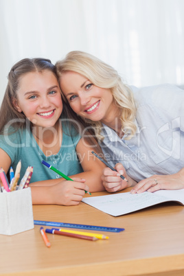 Mother helping daughter with homework in living room