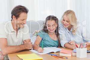 Parents helping her daughter doing her homework