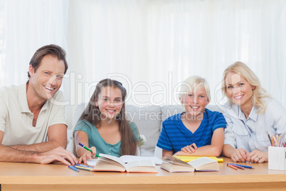 Smiling parents helping their children with their homework