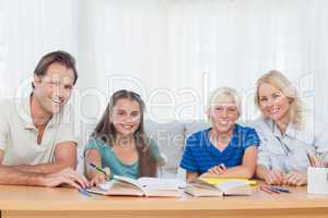 Smiling parents helping their children with their homework