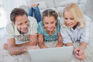 Happy parents and daughter using a laptop
