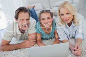 Portrait of parents and daughter using a laptop