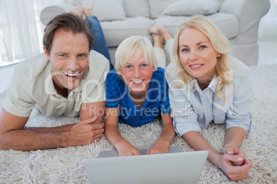 Portrait of son and parents using a laptop