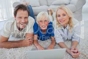 Portrait of son and parents using a laptop