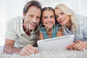 Portrait of a girl and her parents using a tablet